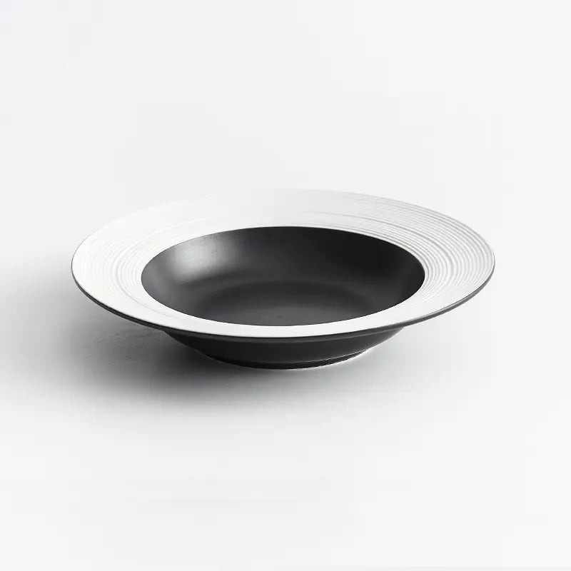 Black bowl with white rim on a light gray background