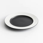 Black plate with white rim on a light gray background