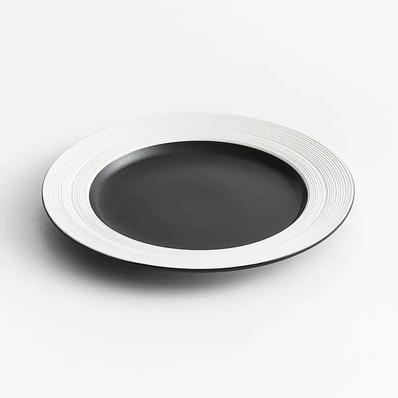 Black plate with white rim on a light gray background
