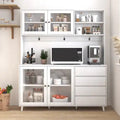 White kitchen cabinet with microwave, coffee maker, and various items on a wooden floor.
