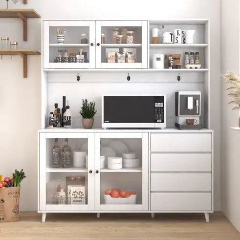 White kitchen cabinet with microwave, coffee maker, and various items on a wooden floor.