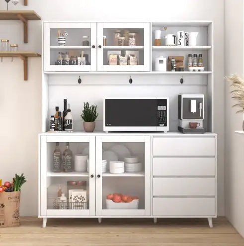 White kitchen cabinet with microwave, coffee maker, and various items on a wooden floor.