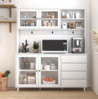 White kitchen cabinet with microwave, coffee maker, and various items on a wooden floor.