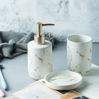 Marble-patterned bathroom set with soap dispenser, tumbler, and dish on a light surface.