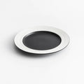 Black plate with white rim on a light gray background