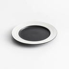 Black plate with white rim on a light gray background